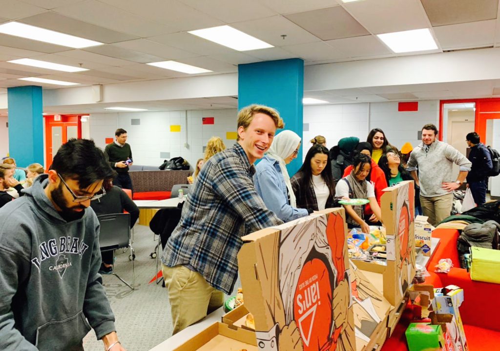 Students in line grabbing pizza. 